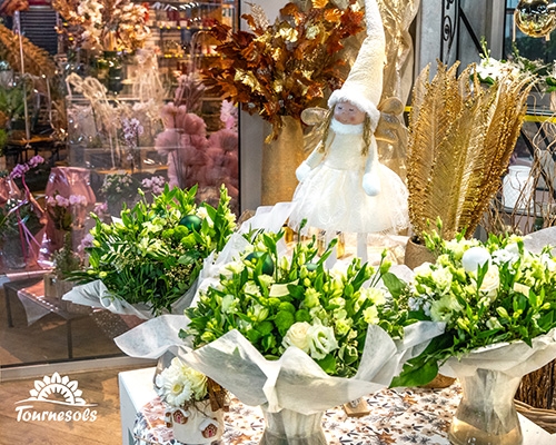 Compositions florales blanches et vertes avec ange décoratif, ambiance élégante du Nouvel An.